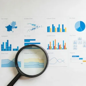 Imagem de uma lupa sobre diversos gráficos em uma folha de papel ilustrando o texto Ferramenta de Diagnóstico de Gestão - Descubra o Que Impede o Crescimento da Sua Empresa