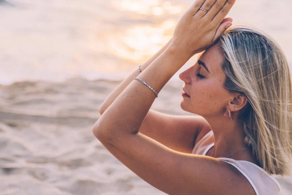 Imagem de uma mulher meditando na praia